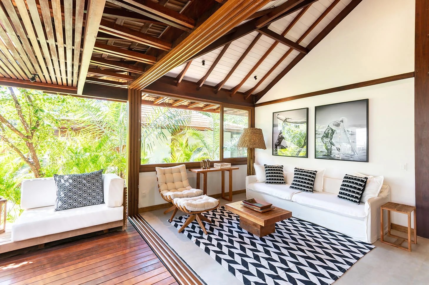Living da Villa 3 com sofá branco, poltrona e portas abertas para a varanda