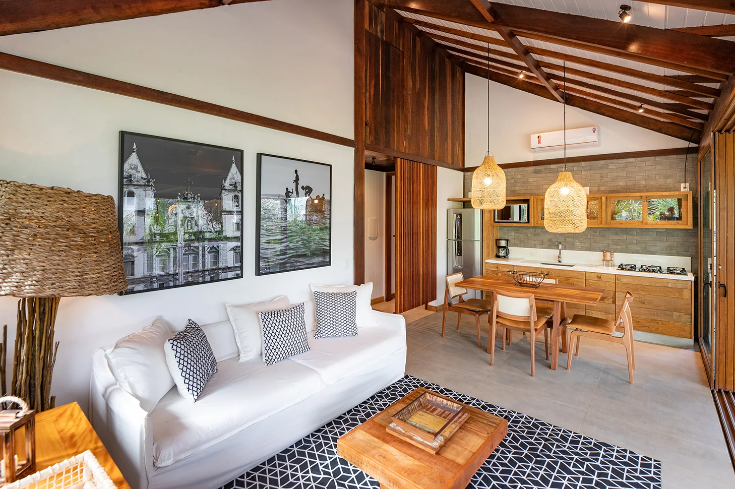 Living da Residência 2 com sofá branco, mesa de centro e cozinha integrada