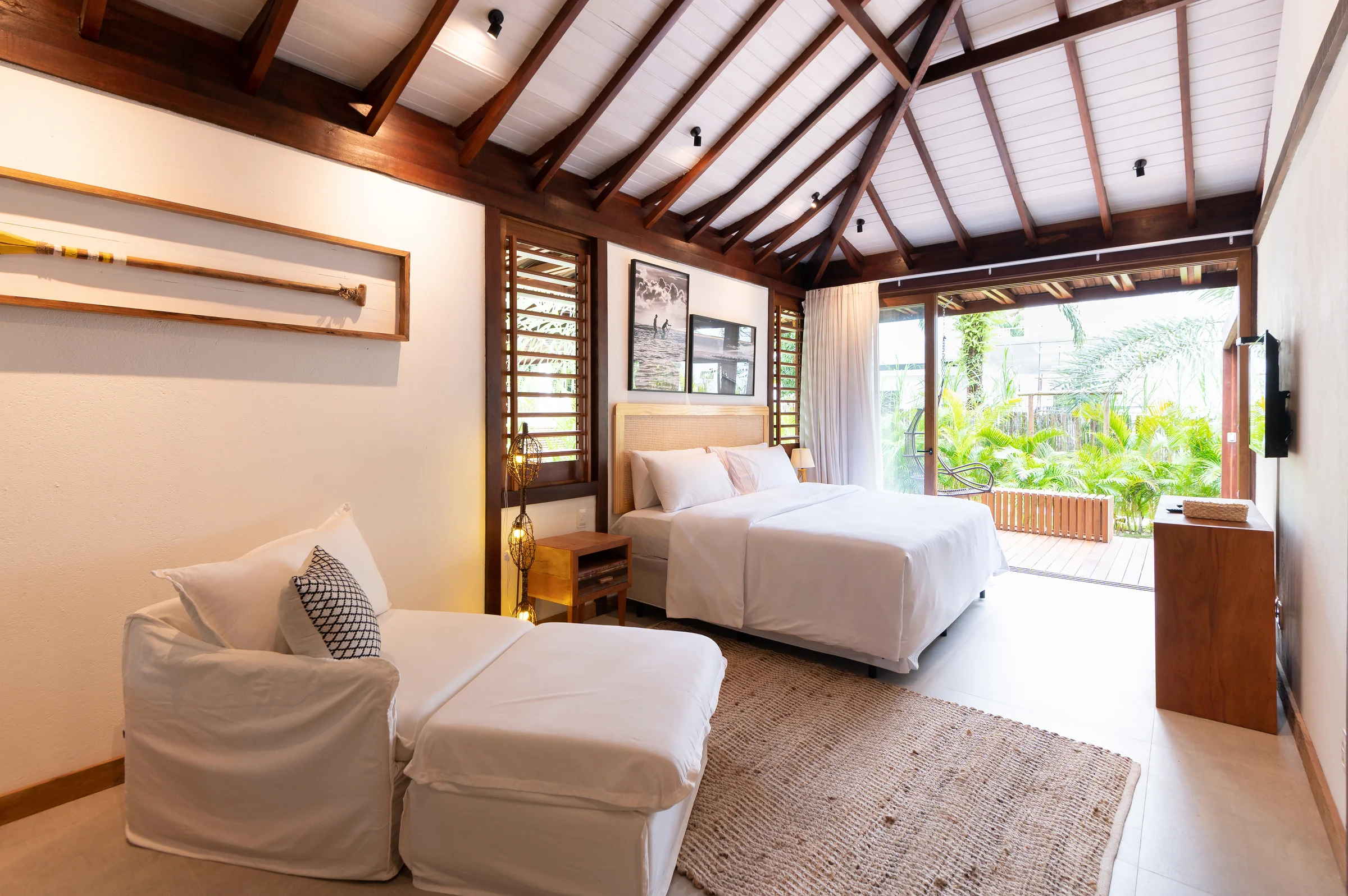 Suíte 3 com cama de casal, chaise e portas de vidro abertas para o jardim